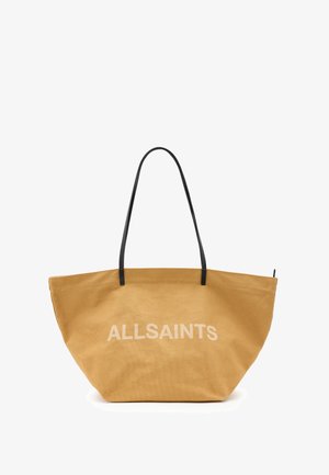 Grote bruine canvas tote bag met zwarte leren handvatten en witte "ALLSAINTS" tekst aan één kant. Heeft een brede opening en een gestructureerde vorm.