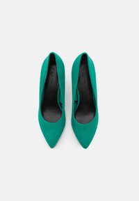 Scarpe con tacco alto in suede verde con punta affusolata e solette nere lisce. Taglia 37 segnata all'interno. Silhouette semplice ed elegante.