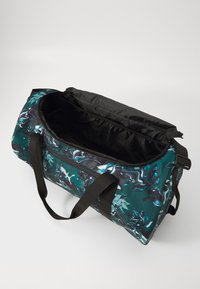 Dufflebag met een teal en zwart gemarmerd patroon, gemaakt van duurzame stof, met een ritsluiting en contrasterende zwarte banden.