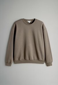 Sudadera marrón hecha de un tejido suave, con cuello redondo, hombros caídos y puños y dobladillo de canalé para un ajuste relajado.