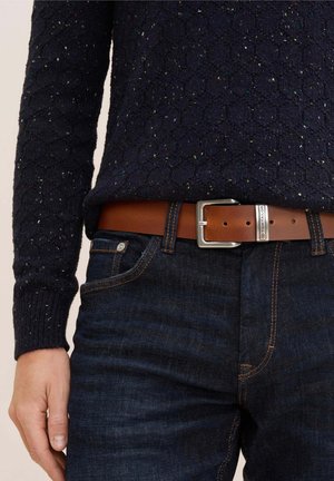 Brown leather belt with silver metal buckle, worn over dark blue denim jeans and a textured navy sweater featuring colorful specks.