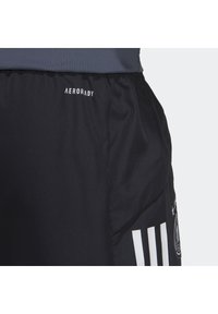 Sorte atletiske shorts med en struktureret overflade, der har hvid AERORADY branding og tre hvide striber på siden.