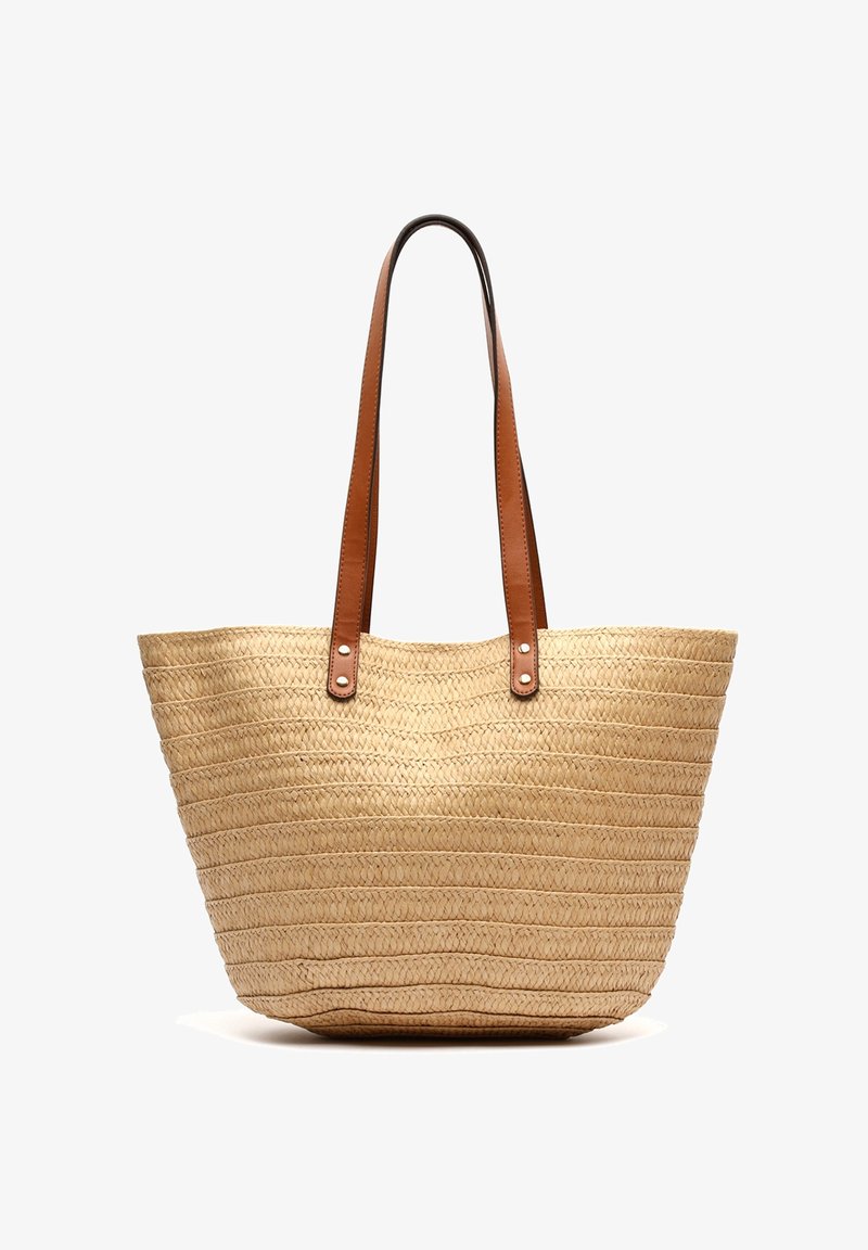 Sac cabas en paille tissée avec motif horizontal et deux longues poignées en cuir marron attachées par des rivets métalliques.