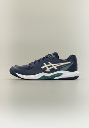 Tumesinine Asics jooksujalats valge tallaga, rohelise keskosa aktsendiga, paeltega disain ja brändiloogoga külgedel.