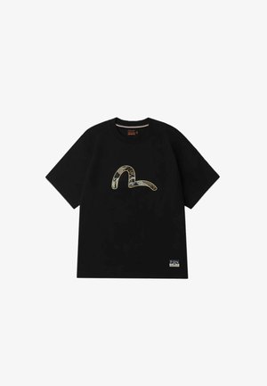 T-shirt nera in cotone con maniche corte, con una grafica a serpente dorato e testurizzato sulla parte frontale e un piccolo etichetta in basso a sinistra.