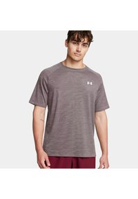 Camiseta atlética gris hecha de material sintético con un patrón de rayas texturizadas y un cuello redondo, con un logotipo blanco en el pecho.