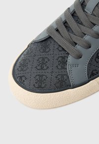 Γκρι αθλητικό παπούτσι με υφασμάτινο επάνω μέρος με ανάγλυφο μοτίβο, λαστιχένια σόλα �και γκρι κορδόνια. Διακοσμημένο με ανοιχτόχρωμη λαστιχένια περίμετρο.