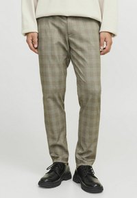 Bruine geruite broek met een slim fit, met een subtiel blauw lijnpatroon. De stof heeft een gladde textuur en is gecombineerd met zwarte schoeisel.