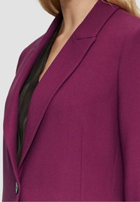 Skräddarsydd kavaj i livlig lila, tillverkad av strukturerad tyg. Har ett snedskuren krage, enkel knappstängning och en elegant design.