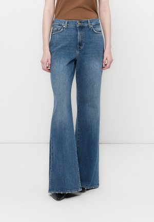 Flarede blå jeans laget av denim, med høy midje, frontlommer og subtil falming. Bunnkanten er uten pynt og rett.