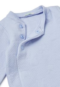 Body per neonati di colore azzurro chiaro realizzato in un tessuto testurizzato con un motivo sottile. Presenta una chiusura con bottoni a pressione e un collo rotondo.