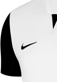 Maglia Nike con un corpo bianco, maniche corte nere e colletto nero. Presenta un logo swoosh nero nella parte anteriore. Texture liscia.