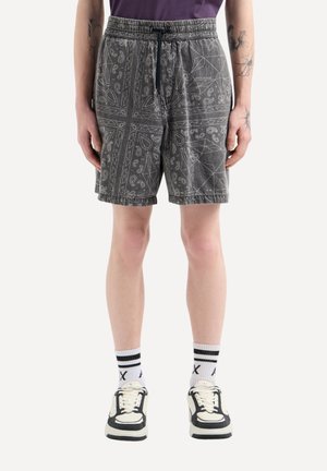 Shorts grigi con motivo elasticizzato in vita e cordoncino. Presentano disegni paisley e geometrici. Abbinate a sneaker bianche e nere.