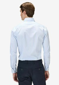 Vaaleansininen ja valkoinen raidoitettu pitkähihaisen paidan klassinen kaulus, tekstuuripinta, napitettu hihansuu ja muotoiltu istuvuus.