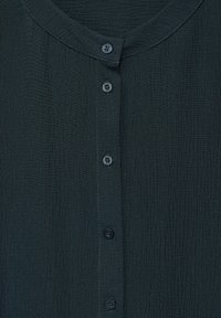 Camicia button-up verde scuro con scollo rotondo, tessuto texturizzato e cinque bottoni coordinati sulla parte anteriore.