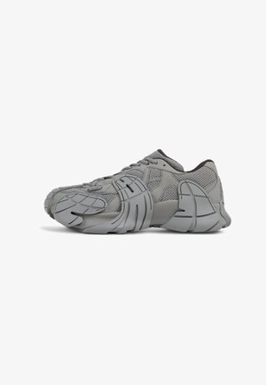 Gray athletic shoes with a mesh and suede upper, featuring a sculpted rubber sole, textured accents, and a lace-up design.
