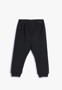 Mørkegrå ribbede bukser med elastisk talje, tapered ben design og tætsiddende manchetter ved anklerne, lavet af blødt stof.