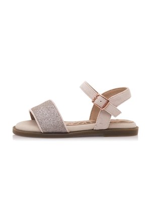 Sandalias planas beige con una correa brillante y un cómodo strap de ante suave en el tobillo con cierre de gancho y bucle. Suela de goma para mayor comodidad y soporte.