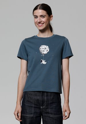 T-shirt en coton bleu foncé avec un graphisme représentant un astronaute de dessin animé tenant un ballon en forme de lune, agrémenté d'étoiles.