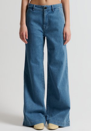 Vaqueros de pierna ancha en azul claro, hechos de denim, con un diseño clásico de cinco bolsillos, lazos para cinturón y un cierre de botón metálico.