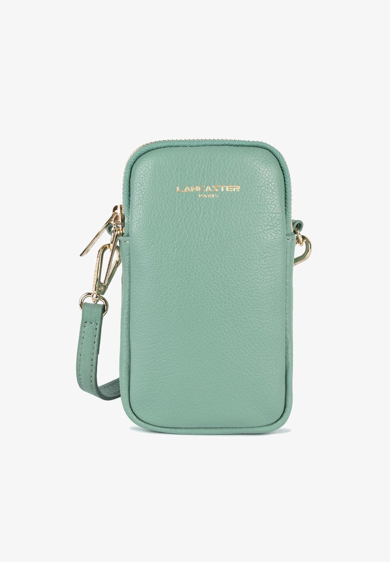 Pochette de téléphone en cuir vert menthe, à porter en travers du corps, avec quincaillerie dorée, fermeture zippée et bandoulière détachable. Présente le logo de la marque en relief à l'avant.