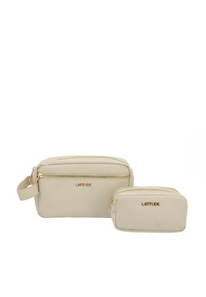 Borse cosmetiche beige realizzate in materiale liscio. Una borsa più grande con zip dorata e tracolla, e una borsa più piccola coordinata. Entrambe presentano il marchio.