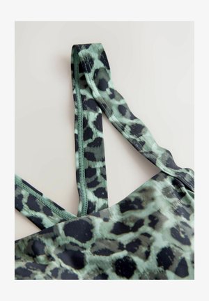 Sportowy top z tkaniny w panterkę w kolorystyce miętowej zieleni i czerni, z gładkimi ramiączkami i dopasowanym fasonem.