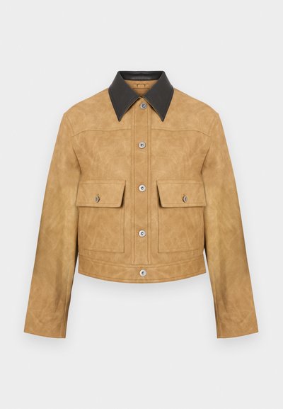 Giacca cropped in pelle color tan con colletto nero, dotata di due tasche frontali e chiusura con bottoni a pressione. Texture liscia con finitura opaca.