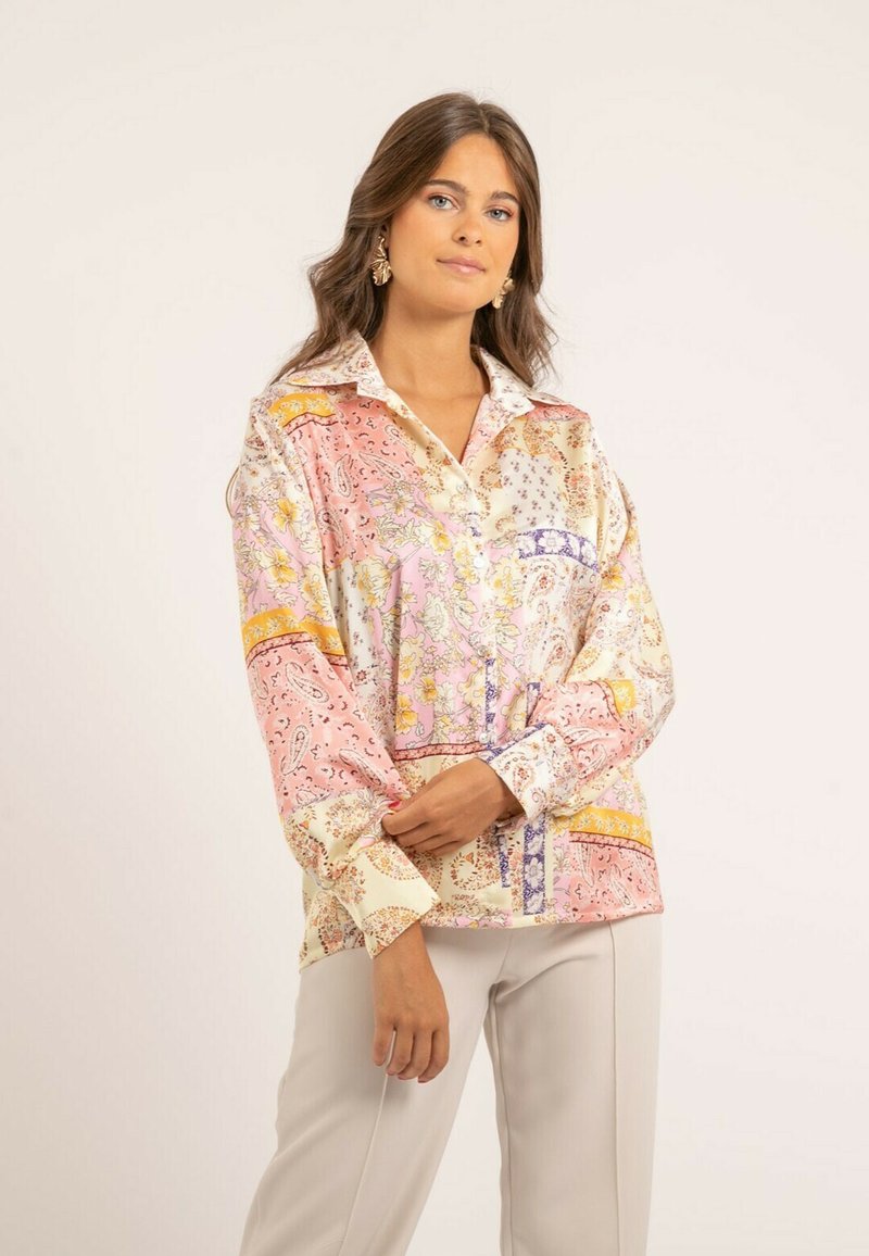 Chemise en soie avec un motif floral et cachemire dans des tons de rose, crème et jaune, dotée d'un col rabattu et de manches longues, amples.