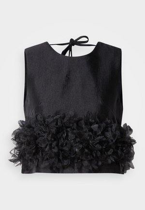 Fekete felső kerek nyakkal és nyitott hátrésszel, a hemjén texturált virágmintás fodorral díszítve. Simább anyag, enyhe fényességgel.