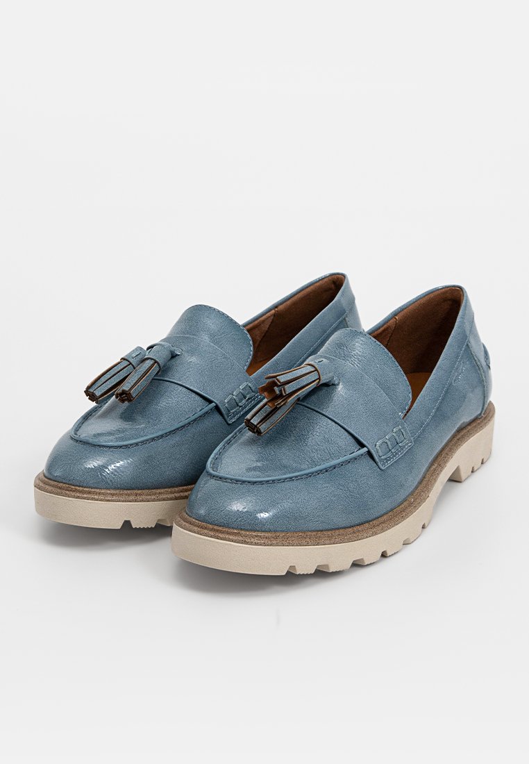 Ein Paar blaue Lederloafers mit beigen klobigen Sohlen und dekorativen Quasten auf einem schlichten weißen Hintergrund.