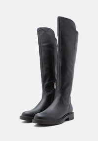 Botas pretas até ao joelho feitas de couro liso. Apresentam um fecho lateral, bico arredondado e uma sola plana com detalhes subtis.