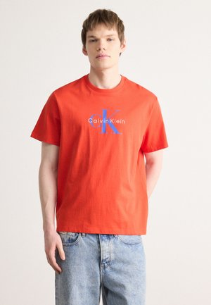 Rode katoenen T-shirt met korte mouwen, met een blauw-witte logo-print "Calvin Klein" op de voorkant. Klassiek ronde hals ontwerp.