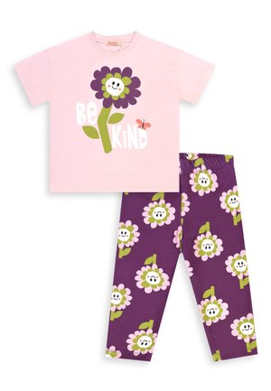 Dziecięcy komplet piżamowy z różową koszulką z krótkim rękawem, na której znajduje się uśmiechnięty fioletowy kwiat i napis „Bądź miły”, w komplecie z fioletowymi spodniami w wzór uśmiechniętych kwiatów.