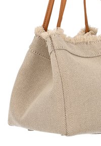 Borsa tote in tessuto beige intrecciato con manici in pelle marrone chiaro e dettaglio di bordo sfrangiato, caratterizzata da un design strutturato e una superficie testurizzata.