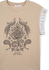 T-shirt di cotone beige con maniche corte a balze, decorato con una stampa paisley e floreale marrone scuro, e il testo "ANDARE CON IL FLUSSO" sottostante.
