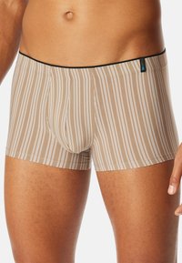 Beżowe bokserki w pasy z czarnym paskiem, z pionowymi białymi paskami i miękką, elastyczną tkaniną dla komfortu.