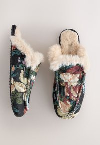 Hausschuhe mit Blumenmuster aus strukturiertem Stoff mit schwarzem Hintergrund, ausgestattet mit einem weichen, cremefarbenen Kunstpelz-Futter und einem Schlupfdesign.