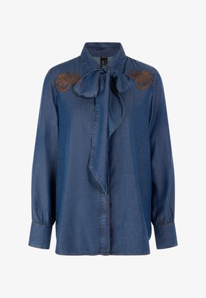 Dunkelblaues Jeanshemd mit langen Ärmeln, Schleifenkrawattenkragen und braunen Stickereiakzenten auf den Schultern. Weiche Textur, lockere Passform.