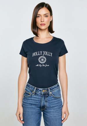 Granatowa bawełniana koszulka z krótkim rękawem, z białym napisem "HOLLY JOLLY" oraz okrągłym logo. W połączeniu z niebieskimi dżinsami z wysokim stanem.