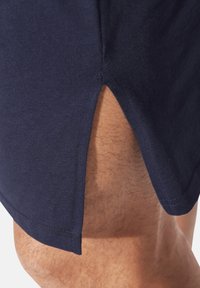 Navy blue cotton shorts with a side slit and stitched hem detailing, showcasing a smooth texture and fitted design.