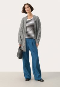 Gray knit cardigan, striped navy and white top, blue wide-leg pants, and black flat shoes. Model holding a small black handbag.