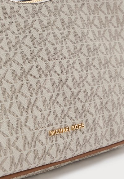 Бежова чанта Michael Kors с шаблон с повтарящи се лога "MK" и златиста табелка с надпис "MICHAEL KORS" близо до долния ръб.