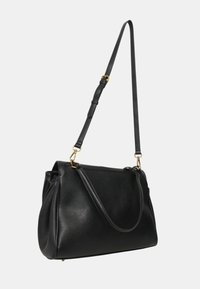 Borsa a tracolla in pelle nera con una forma strutturata, cintura regolabile singola e dettagli in metallo dorato. Texture liscia, senza motivi.