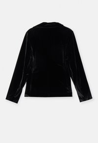 Chaqueta de terciopelo negro con cuello, mangas largas y un corte ajustado. Textura suave, sin herrajes visibles y líneas limpias en la parte posterior.