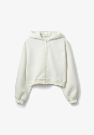 Hanorac scurt alb cu fermoar, din material moale, prevăzut cu glugă mare, umeri căzuți și manșete din rețea la mâneci și tiv.