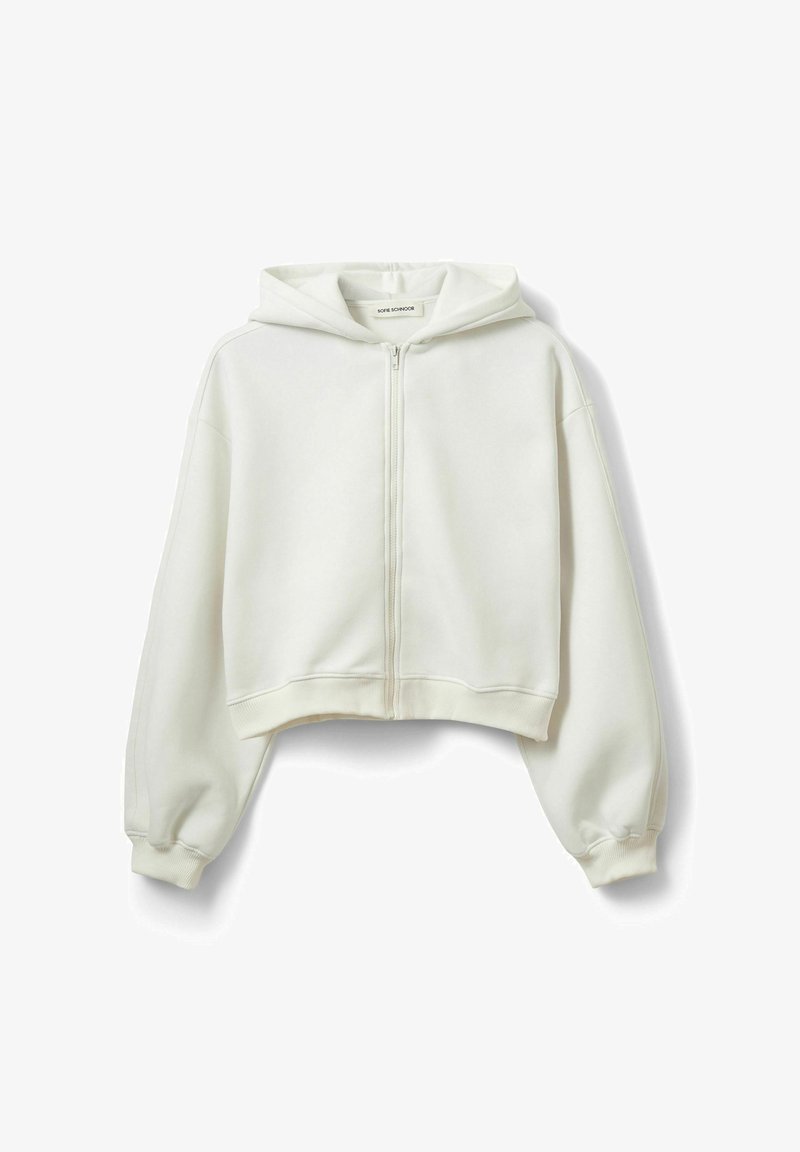 Baltas trumpintas užsegamas užtrauktuku džemperis iš minkštos medžiagos, su dideliu gobtuvu, nuleistomis pečių siūlėmis ir ribotais rankogaliais bei apačioje.