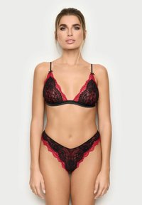 Schwarzes Spitzen-Unterwäsche-Set mit einem Bralette mit roten Spitzenakzenten und verstellbaren Trägern, kombiniert mit passendem String-Unterwäsche.