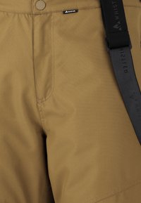 Beige shorts van een gladde stof, met een logo en een band. Het ontwerp omvat een knoop op de tailleband en details van zijnaadsteken.