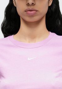 Μπλούζα φούτερ με στρογγυλή λαιμόκοψη σε αποχρώσεις λεβάντας, κατασκευασμένη από απαλό βαμβακερό μείγμα, με μικρό λευκό λογότυπο Nike στο στήθος και ριμπ λαιμόκοψη.